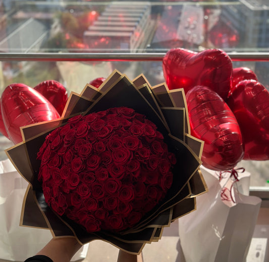 Ramo de 101 rosas rojas naturales con globos en forma de corazón, ideal para sorprender a tu pareja