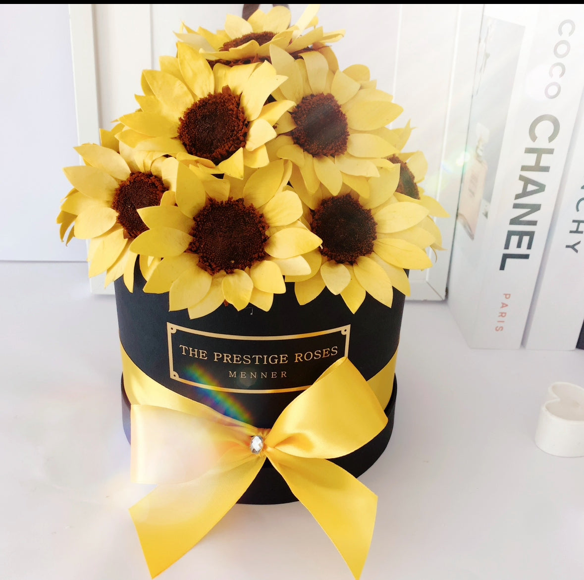 Caja de girasoles frescos con envoltura de lujo, ideal para regalos.