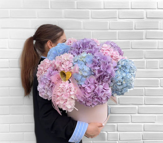 Ramo de hortensias pastel en tonos rosa, azul y lila con presentación elegante.